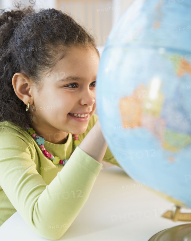Hispanic girl looking at globe