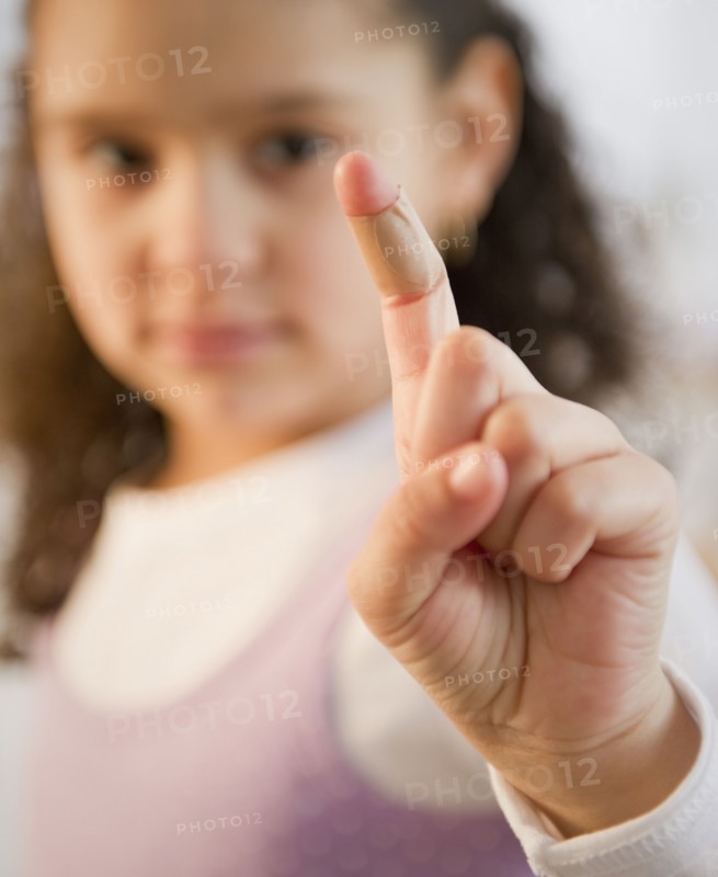 Hispanic girl with bandage on finger