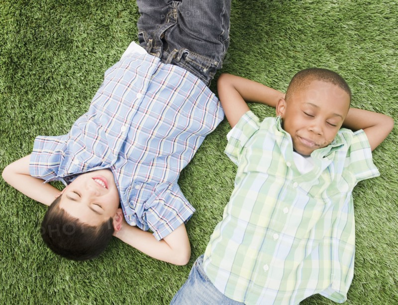 Boys sleeping in grass