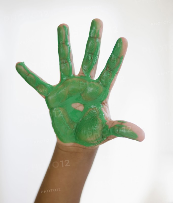 Black boy with green paint on hand