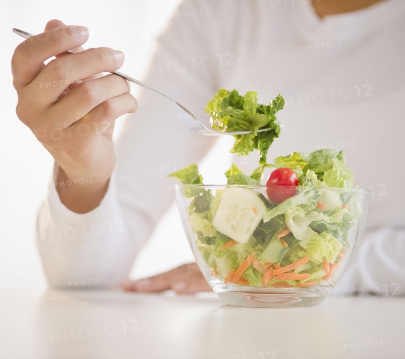 Mixed race woman eating salad