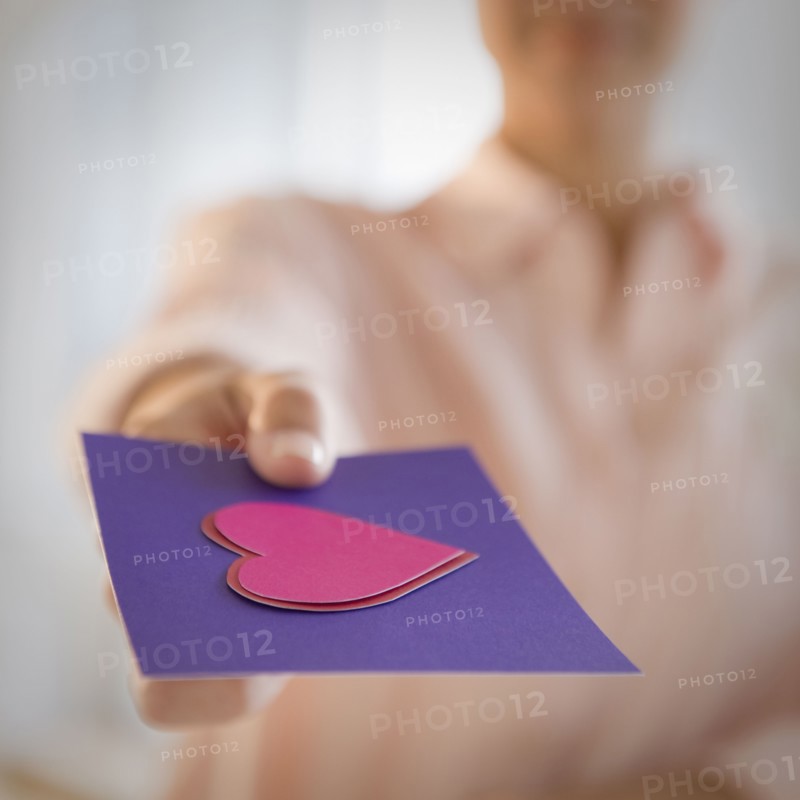 Mixed race woman giving valentine card