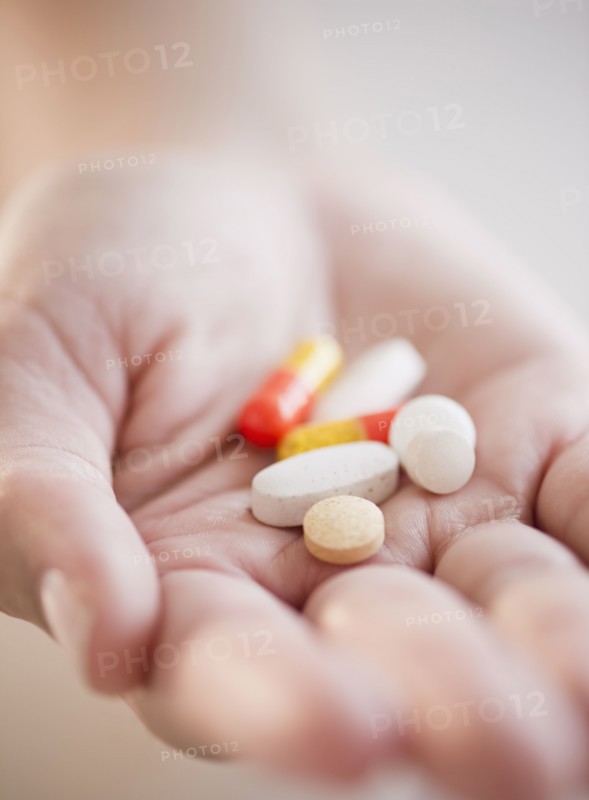 Hand holding pills and capsules