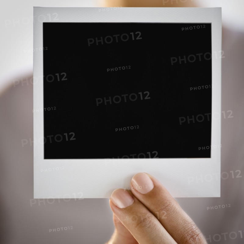 Hand holding blank Polaroid picture film