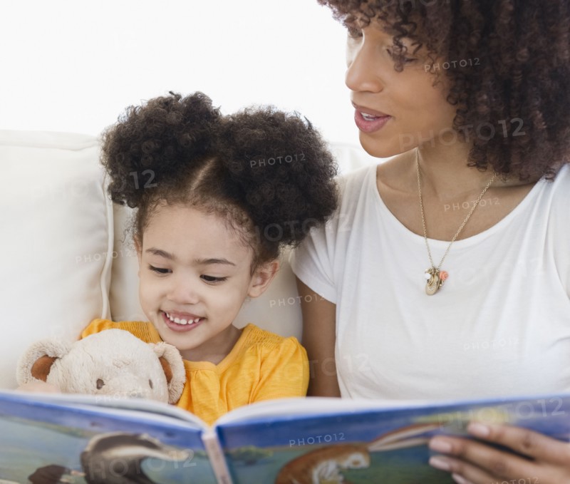 Woman reading book with daughter
