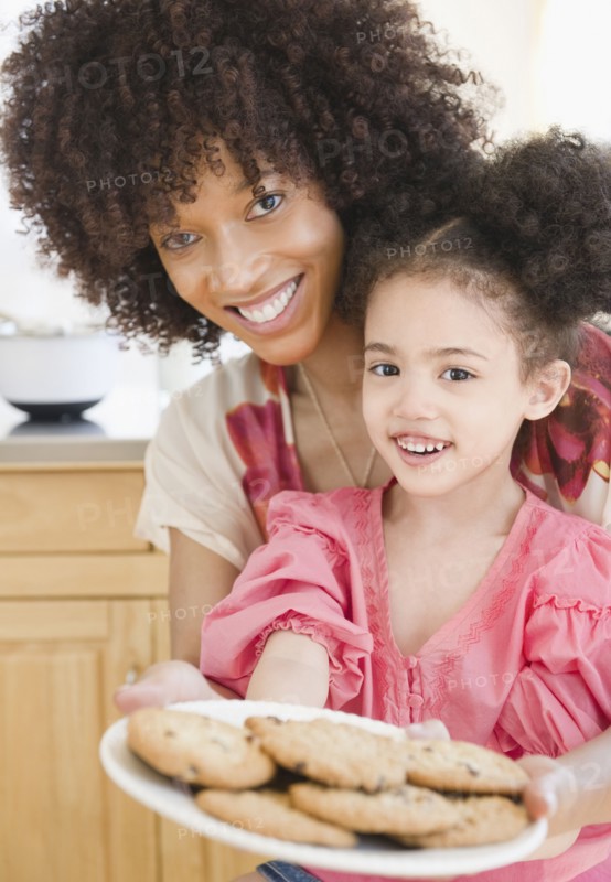 Mother and daughter holding plate of cookies