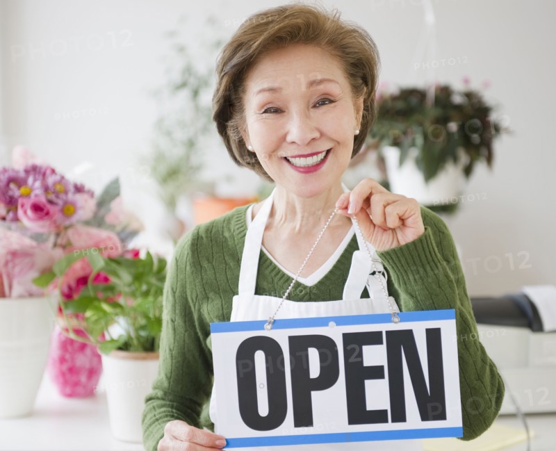 Japanese florist holding open sign