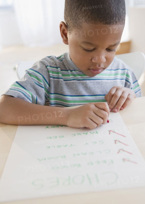 African American boy checking list of chores