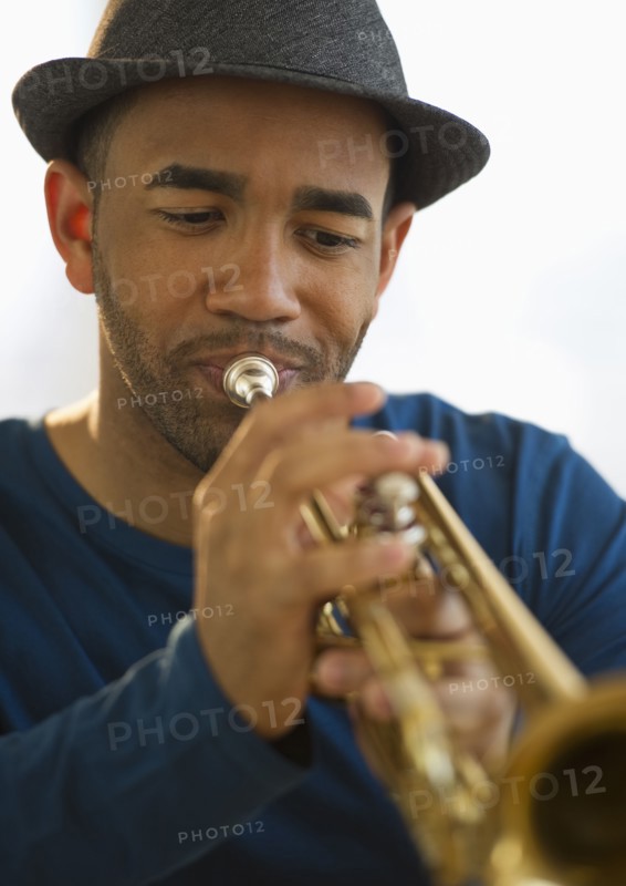 Mixed race man playing trumpet