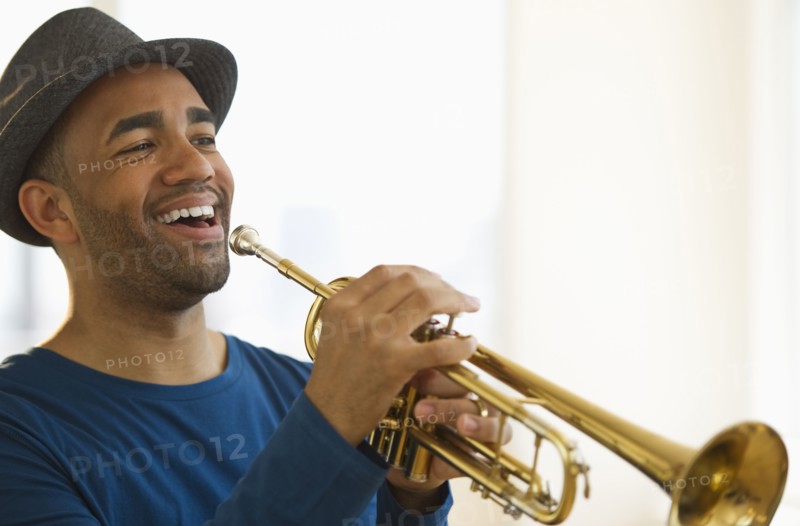 Mixed race man playing trumpet