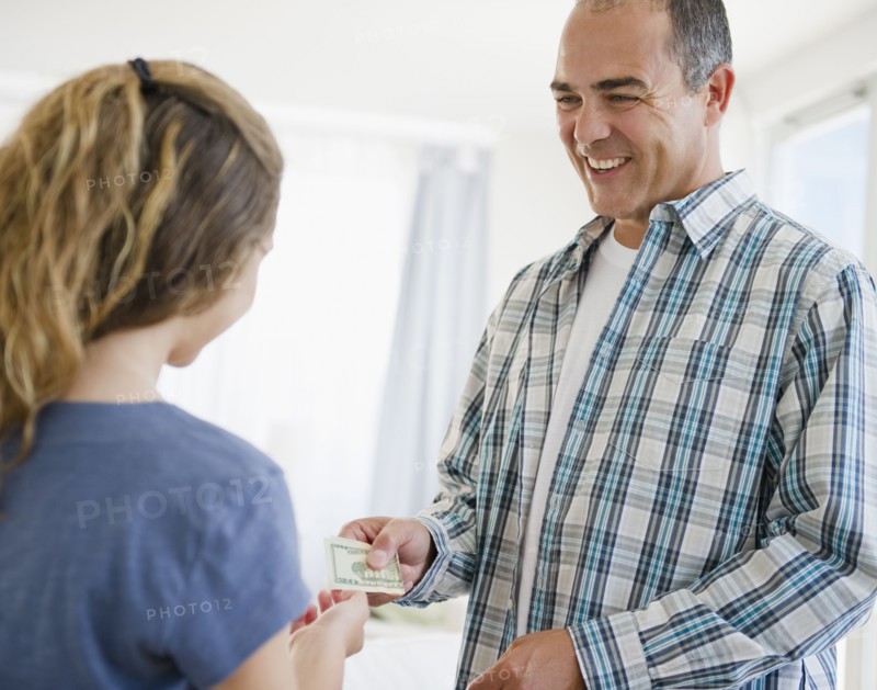 Hispanic father handing daughter money