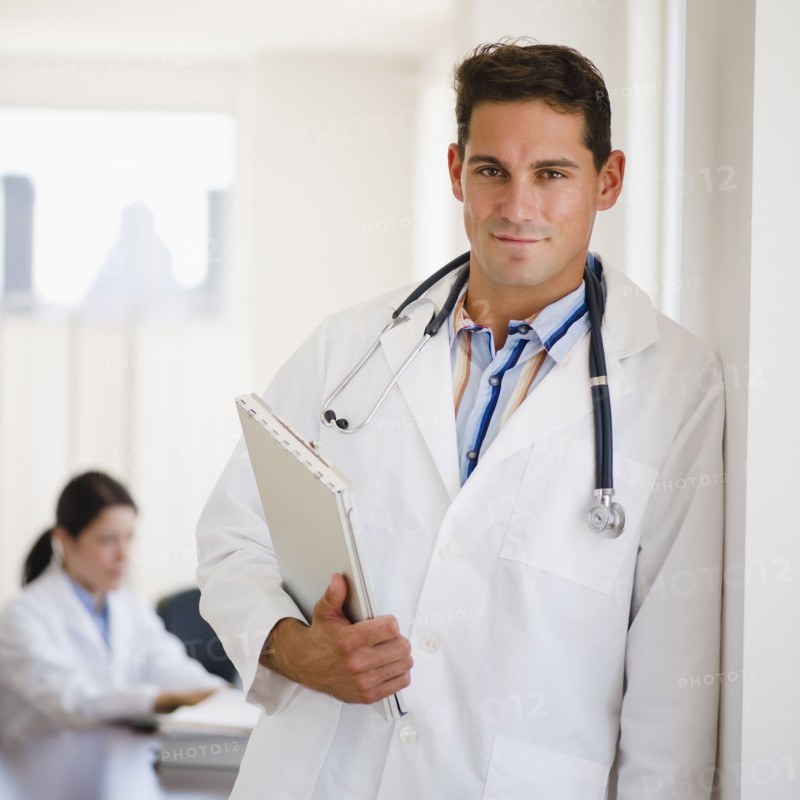 Mixed race doctor holding medical record in doctor's office