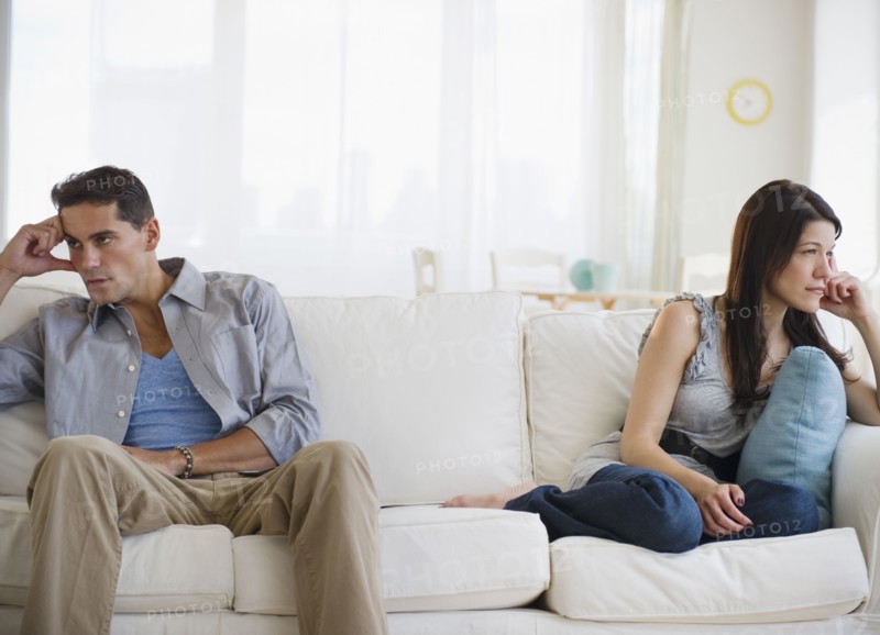 Angry mixed race couple having argument on sofa