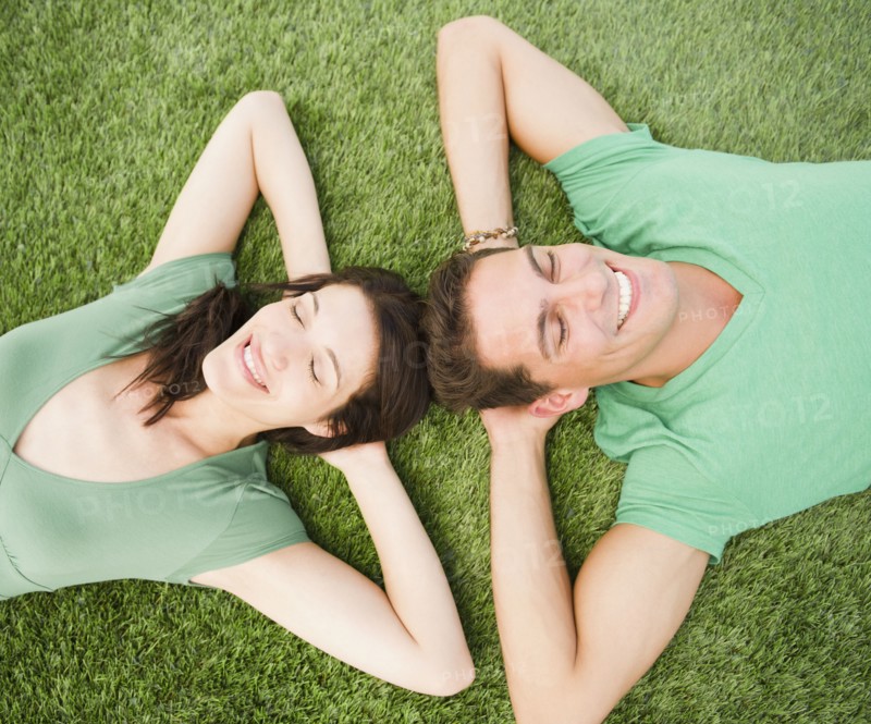 Smiling couple laying in grass together