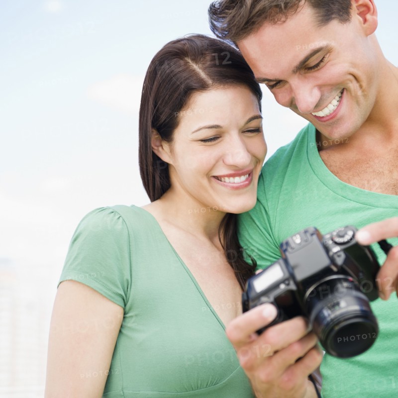 Smiling couple looking at back of digital camera together
