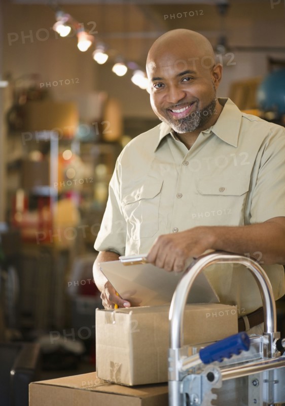 African American deliveryman with clipboard and boxes