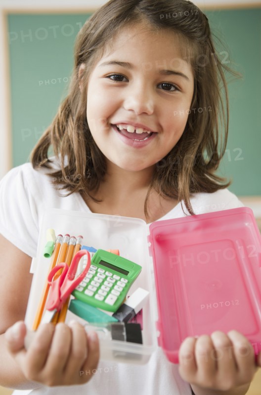 Hispanic girl holding school supplies