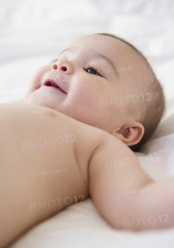 Mixed race baby laying on bed
