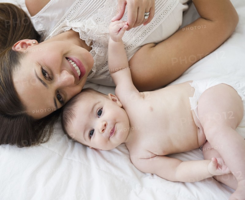 Mother laying on bed with baby