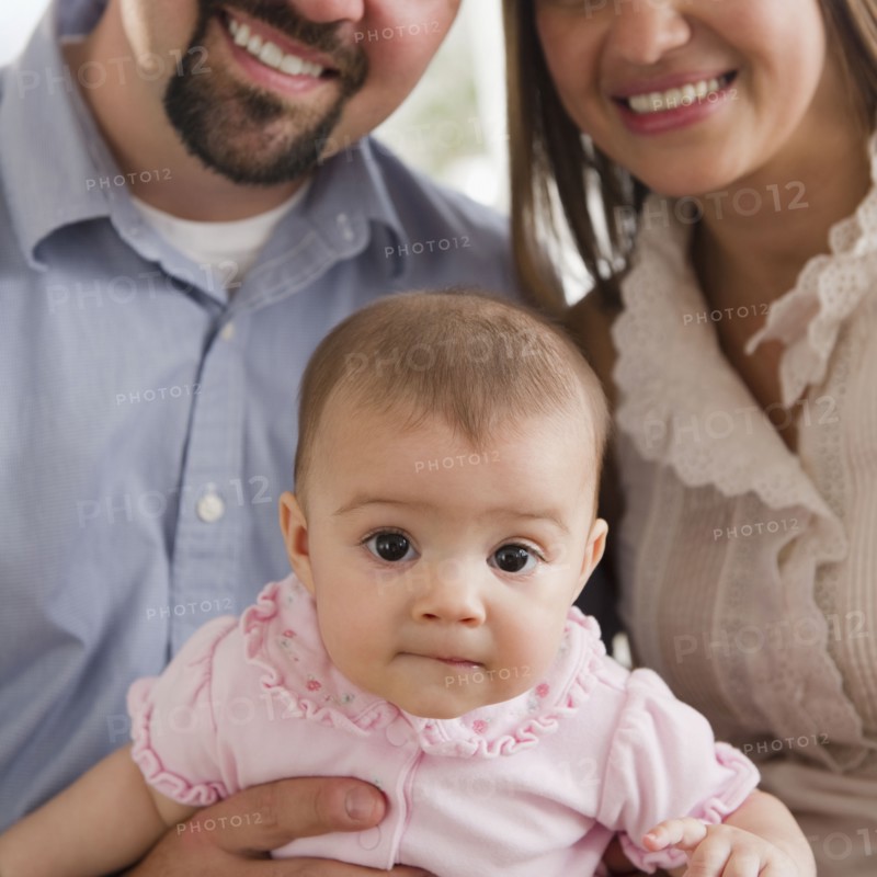 Mother and father holding baby daughter