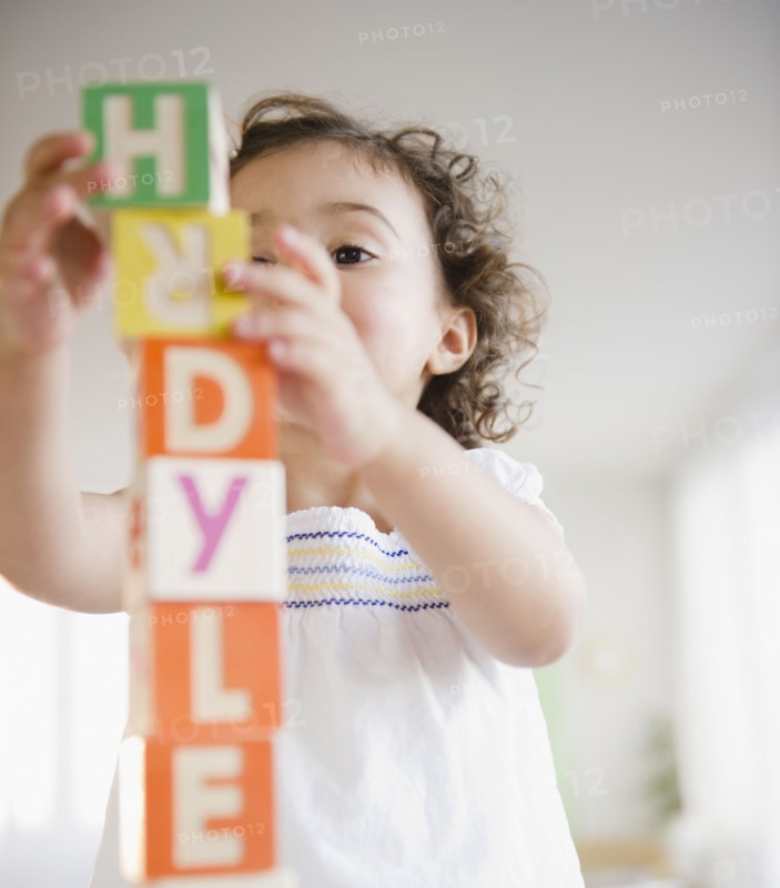 Mixed race girl stacking blocks