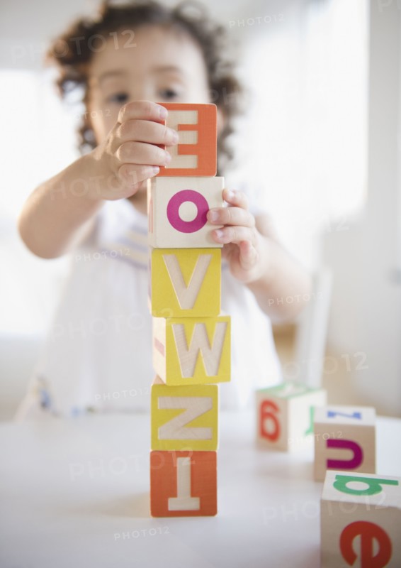 Mixed race girl stacking blocks