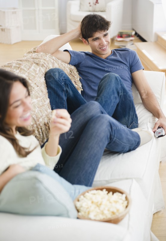 Couple eating popcorn and watching television
