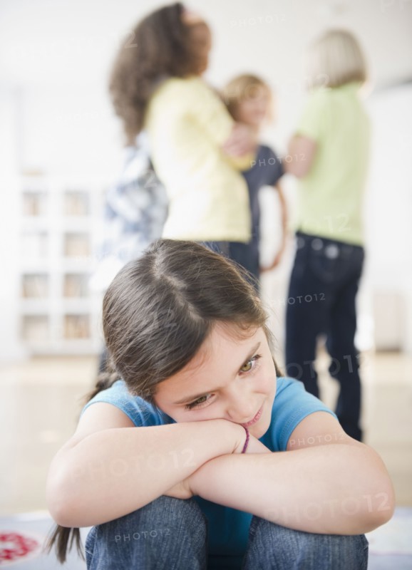 Lonely girl ignoring friends playing