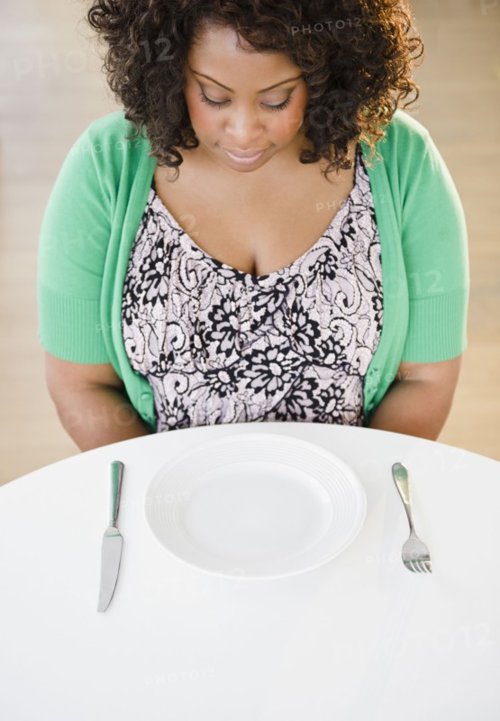 African American woman looking at empty plate