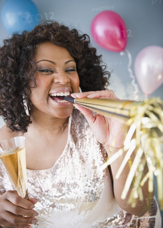 African American woman with noise maker and glass of Champagne