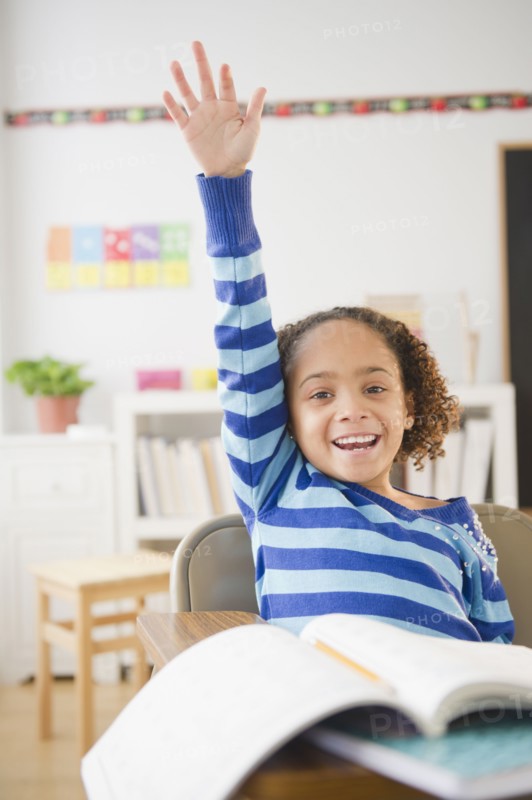 African American girl raising hand in classroom