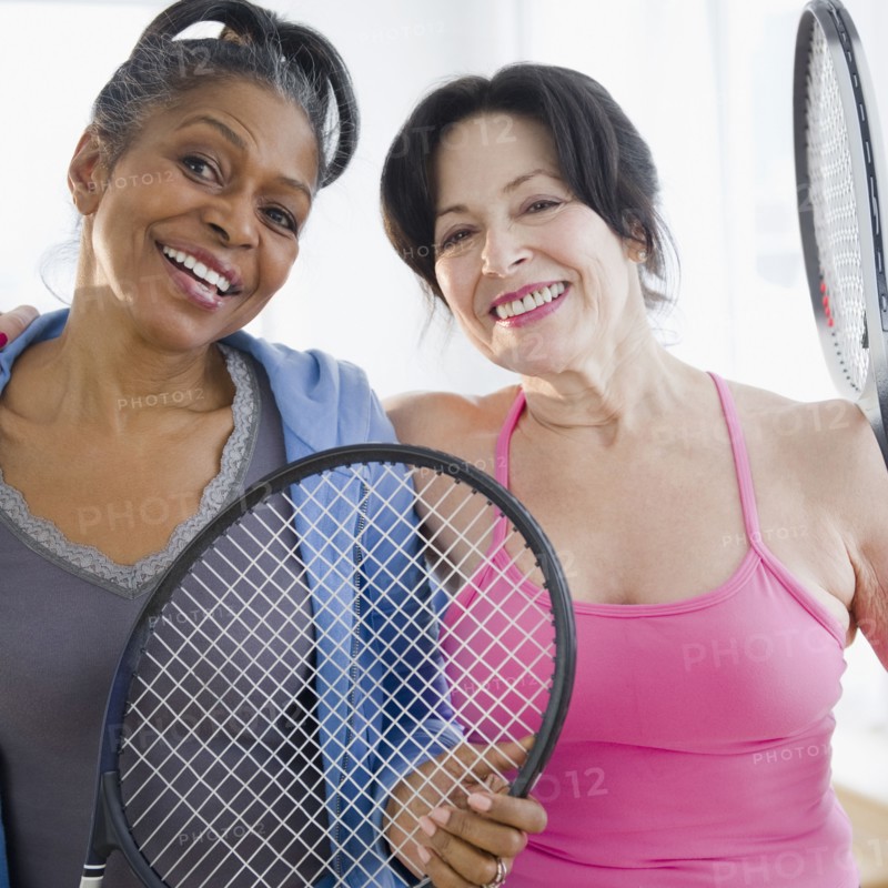 Friends standing together with tennis racquets