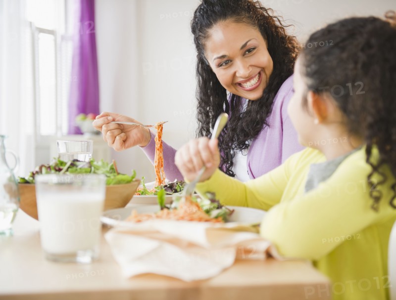 Mother and daughter eating dinner together