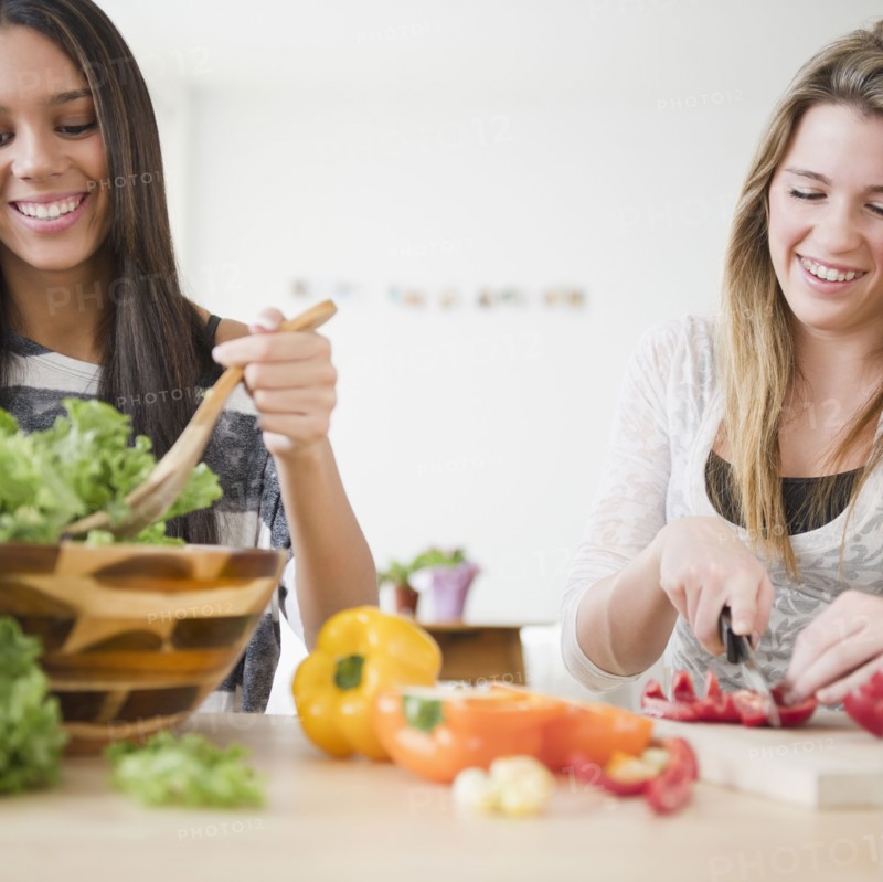 Teenage girls preparing salad together