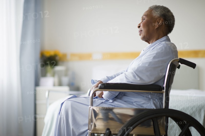 Black woman sitting in wheelchair in  hospital