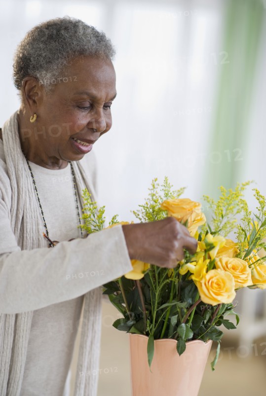 Black woman arranging roses in vase