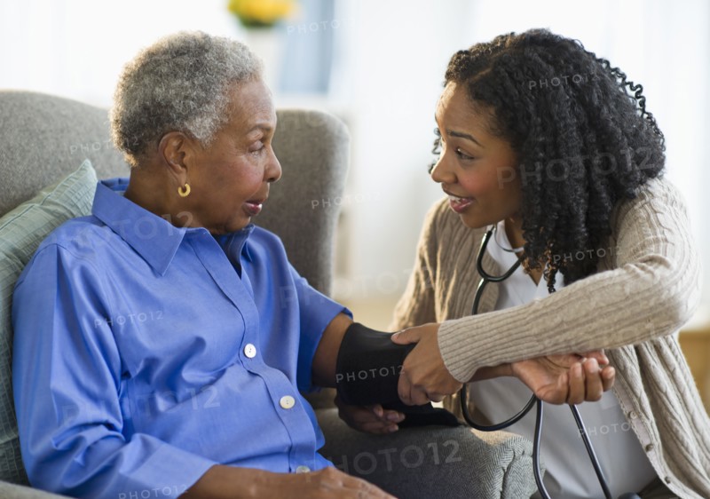 Nurse taking woman's blood pressure
