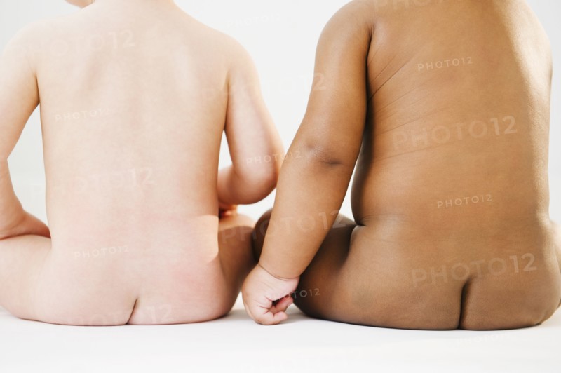 Nude babies sitting on floor