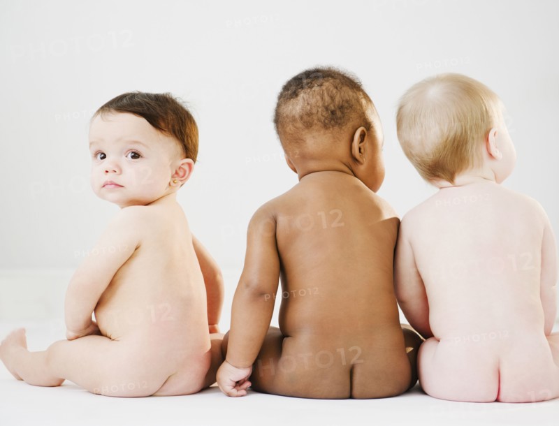 Nude babies sitting on floor