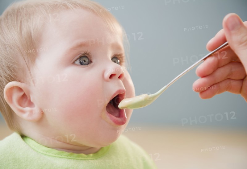 Mother feeding Caucasian baby