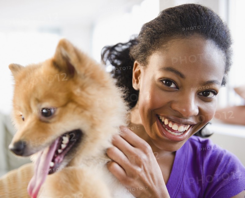 Mixed race woman petting Pomeranian dog
