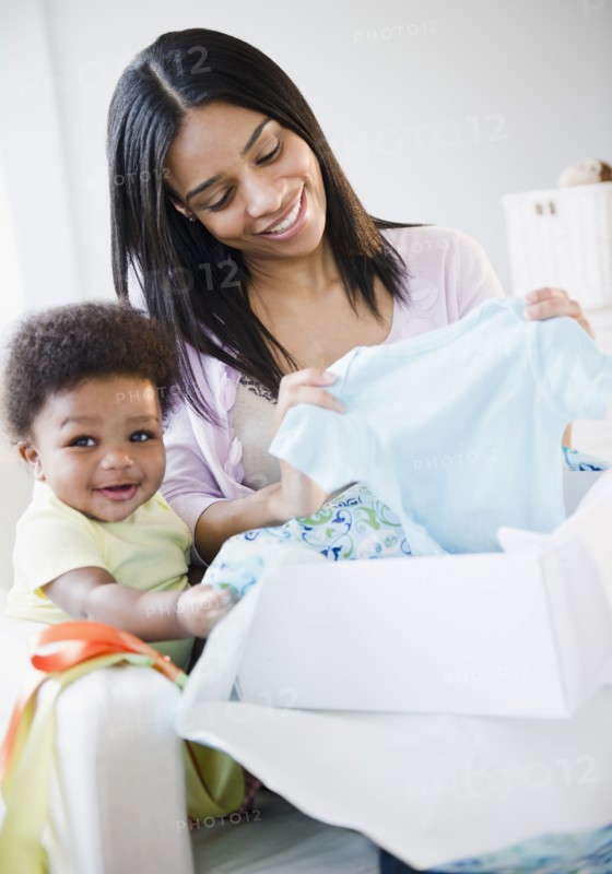 African American mother and baby boy opening gift