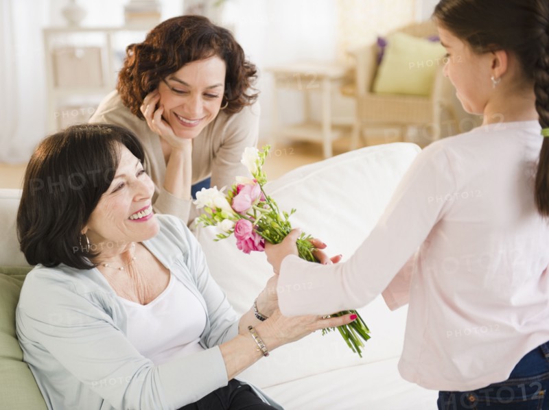 Granddaughter giving grandmother bouquet of flowers
