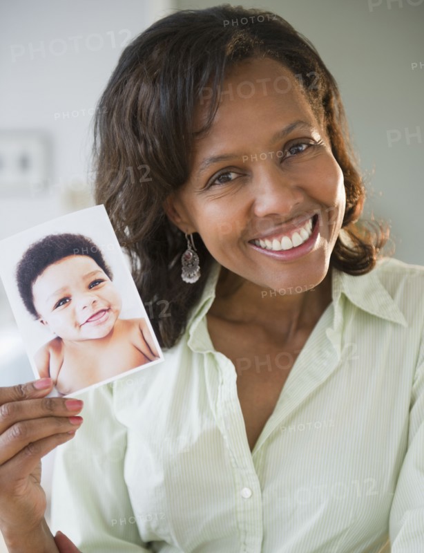 Black woman holding photograph of baby