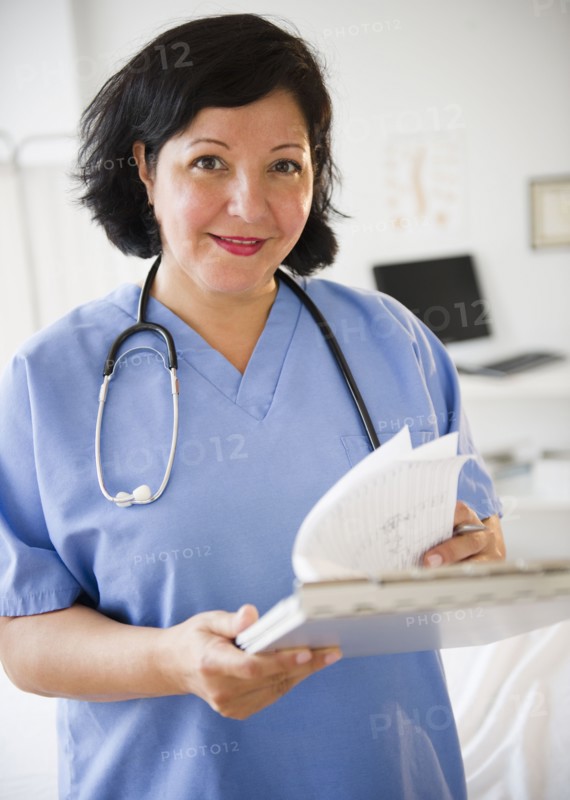 Hispanic doctor looking at medical chart