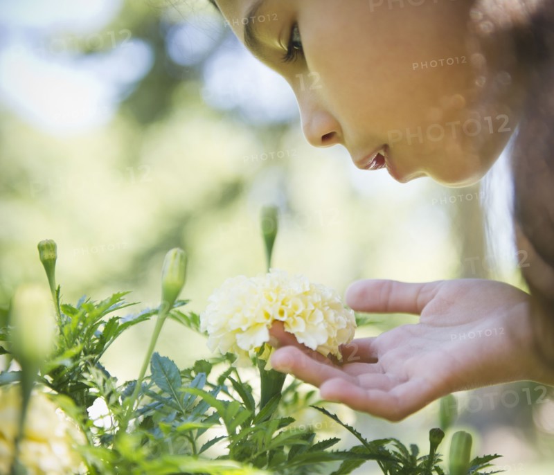 Hispanic girl smelling flower