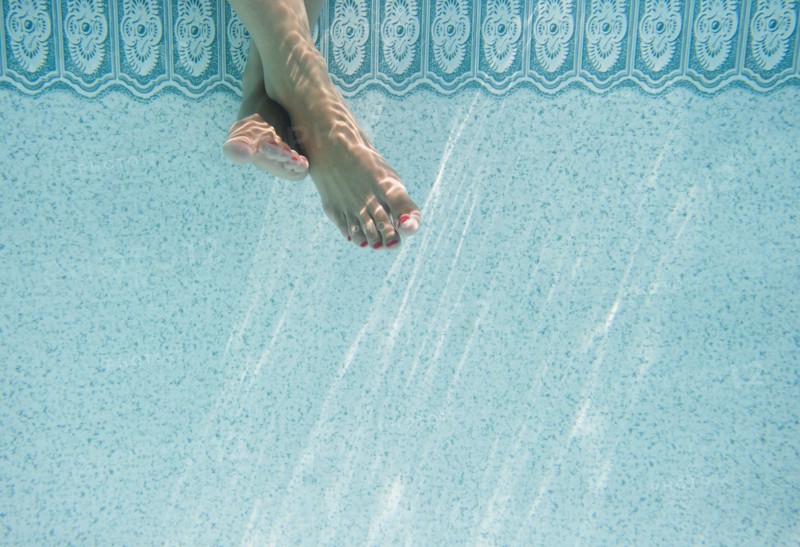 Caucasian woman's feet underwater in swimming pool