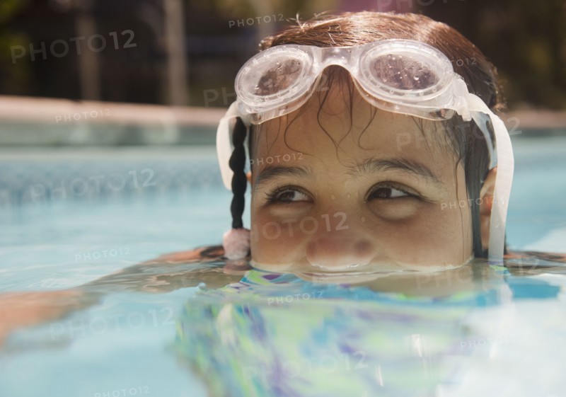 Hispanic girl swimming in swimming pool
