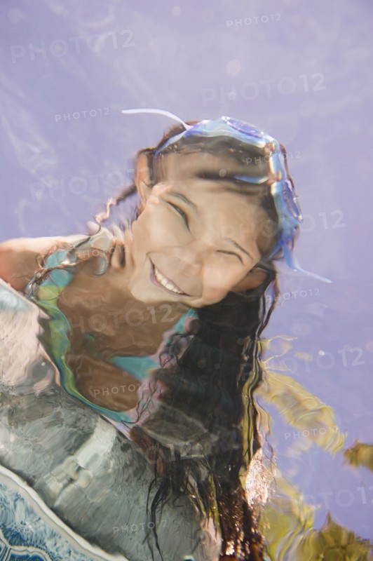 Hispanic girl looking into swimming pool