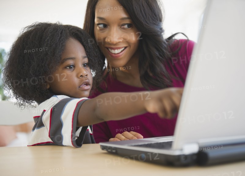 African American mother and son using laptop together